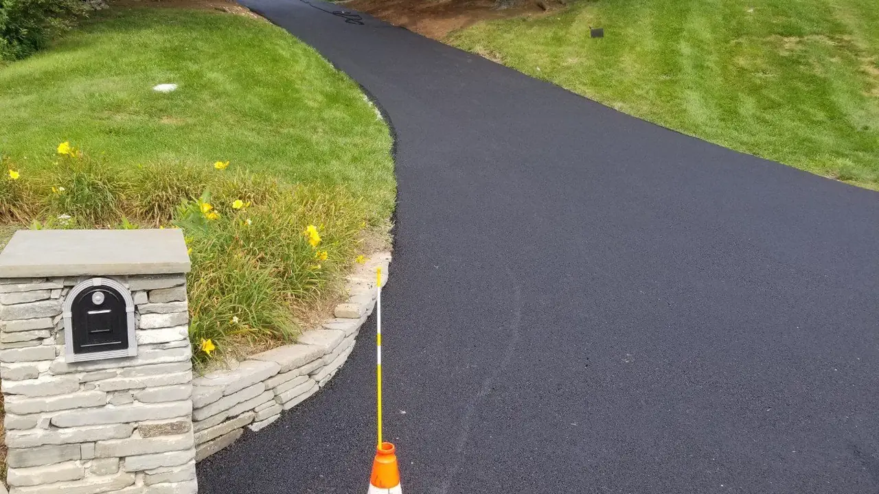 Residential asphalt driveway with a stone mailbox pillar