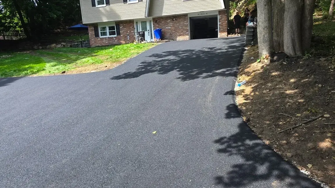 Freshly paved residential asphalt driveway with clean edges