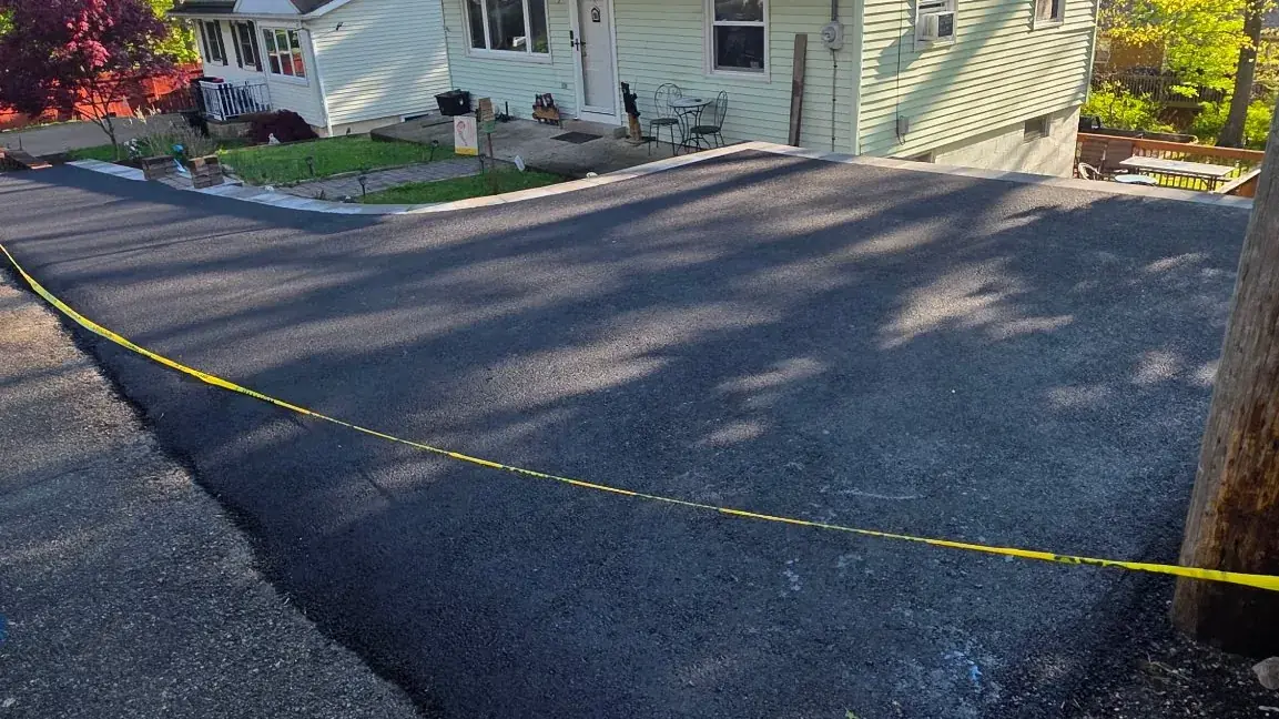 Freshly paved residential asphalt driveway with clean edges